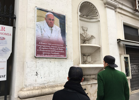 Papstkritisches Plakat in Rom / Copyright 2017, KNA. Alle Rechte vorbehalten, Paul Haring Ein papstkritisches Plakat an einer Wand in Rom am 5. Februar 2017. Zwei Passanten stehen davor und betrachten das Plakat. Unter dem Foto von Papst Franziskus steht in römischem Dialekt: 'Franziskus, du hast Kongregationen unter kommissarische Leitun
