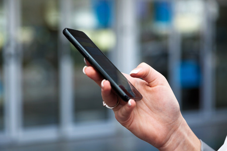Frau schreibt eine SMS mit ihrem Handy / Erwin Wodicka - wodicka@aon.at Gesch